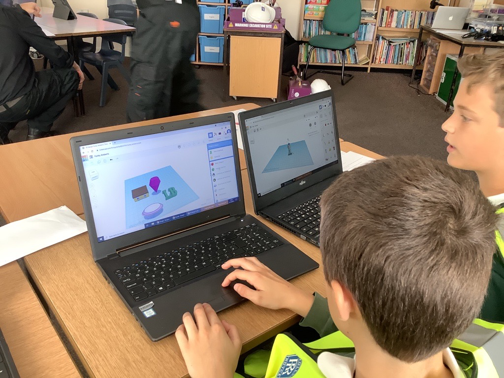 Children using a laptop to control a 3D printer