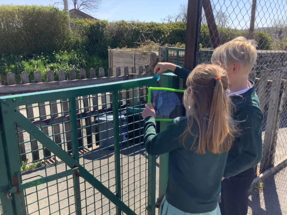 Two children measuring a post in the school playground