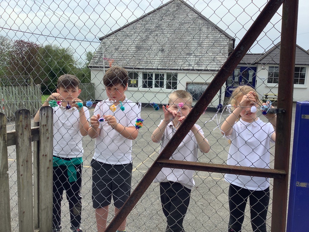 Two children measuring a post in the school playground